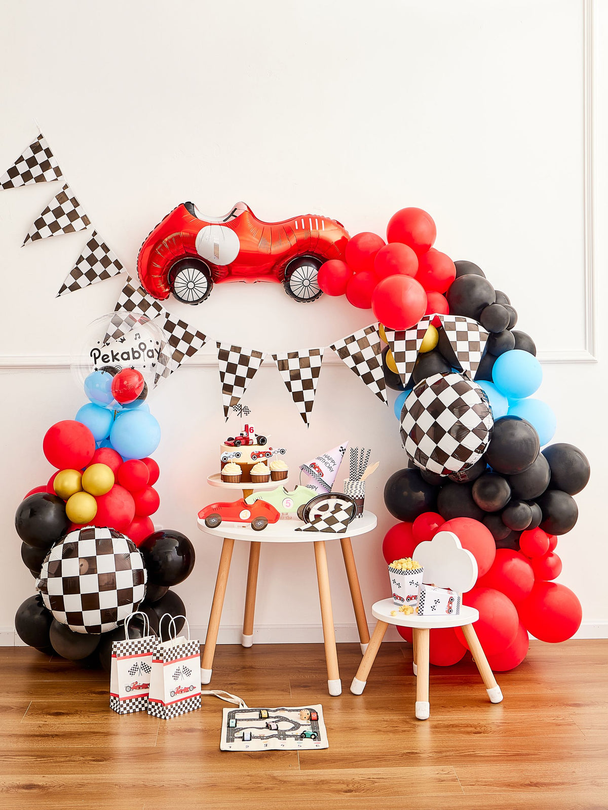 Pekaboay Race Car Themed Children’s Party Supply Kit including cups, cupcake toppers, cutlery, banners, foil balloon, balloon garland, straws, napkins, 7-inch plates, and 9-inch plates