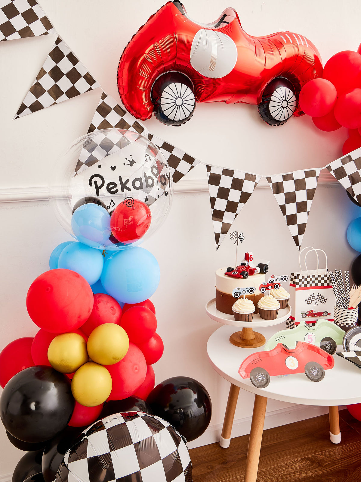 Pekaboay Race Car Themed Children’s Party Supply Kit including cups, cupcake toppers, cutlery, banners, foil balloon, balloon garland, straws, napkins, 7-inch plates, and 9-inch plates