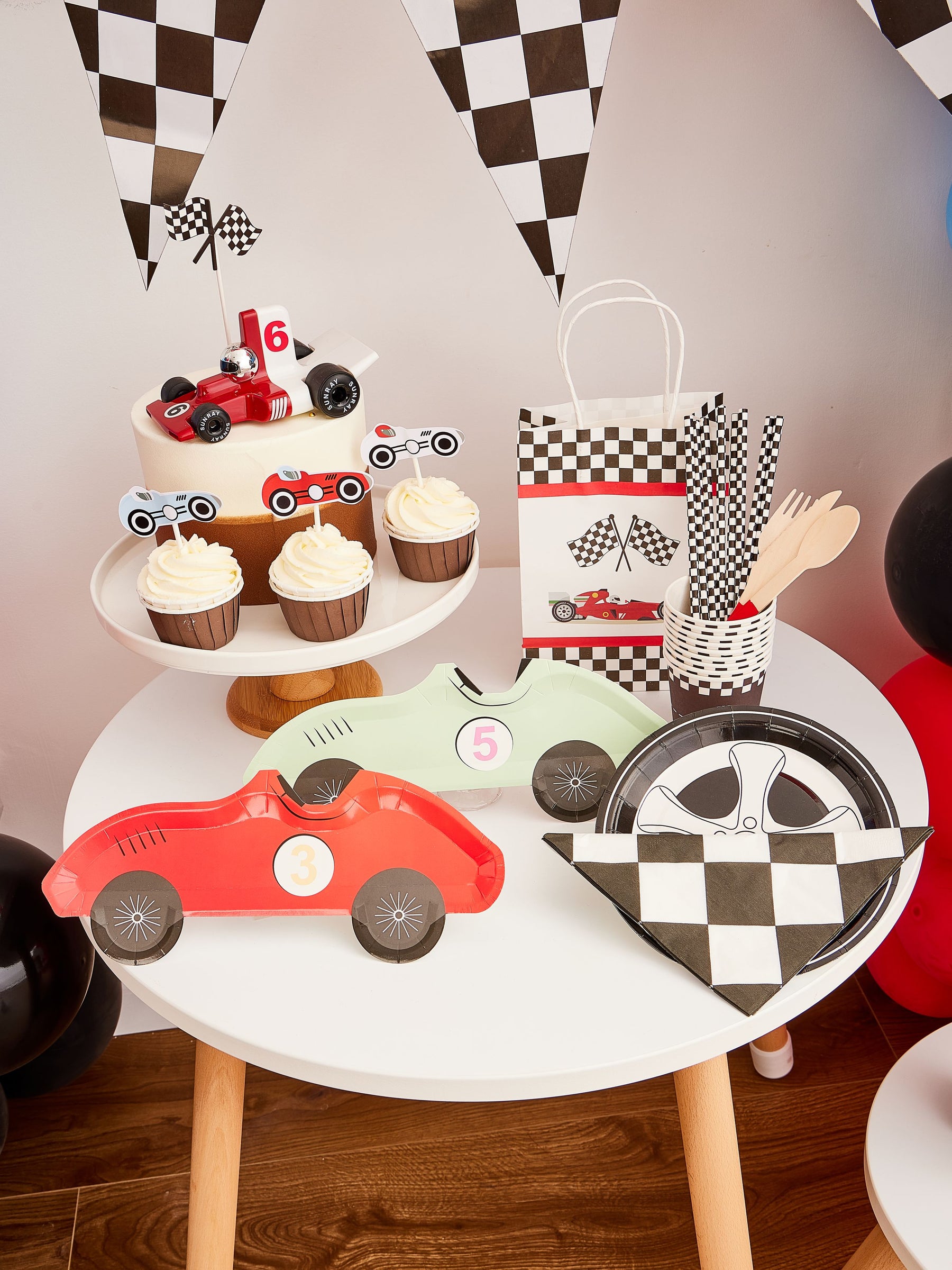 Pekaboay Race Car Themed Children’s Party Supply Kit including cups, cupcake toppers, cutlery, banners, foil balloon, balloon garland, straws, napkins, 7-inch plates, and 9-inch plates